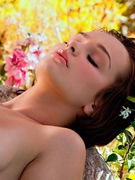 Hailee Rain lays on the rocks by the water