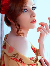Redhead girl stripping in white studio with..